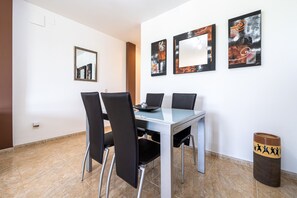 A dining area with a table, chairs, and artwork on the walls.