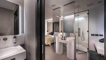 A modern bathroom with a large mirror, a bathtub, and a shower area.