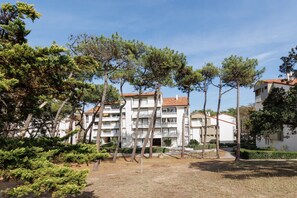 A residential building with multiple floors, balconies, and a clear sky.