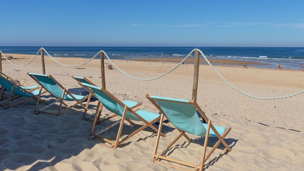 A beach with rows of blue beach chairs and a rope barrier. - Studio Seignosse near the "Le Penon" beach (1 min) with balcony (Seignosse)