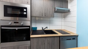 A modern kitchen with stainless steel appliances, a built-in oven, a microwave, a sink, and a dishwasher. - Studio Seignosse near the "Le Penon" beach (1 min) with balcony (Seignosse)