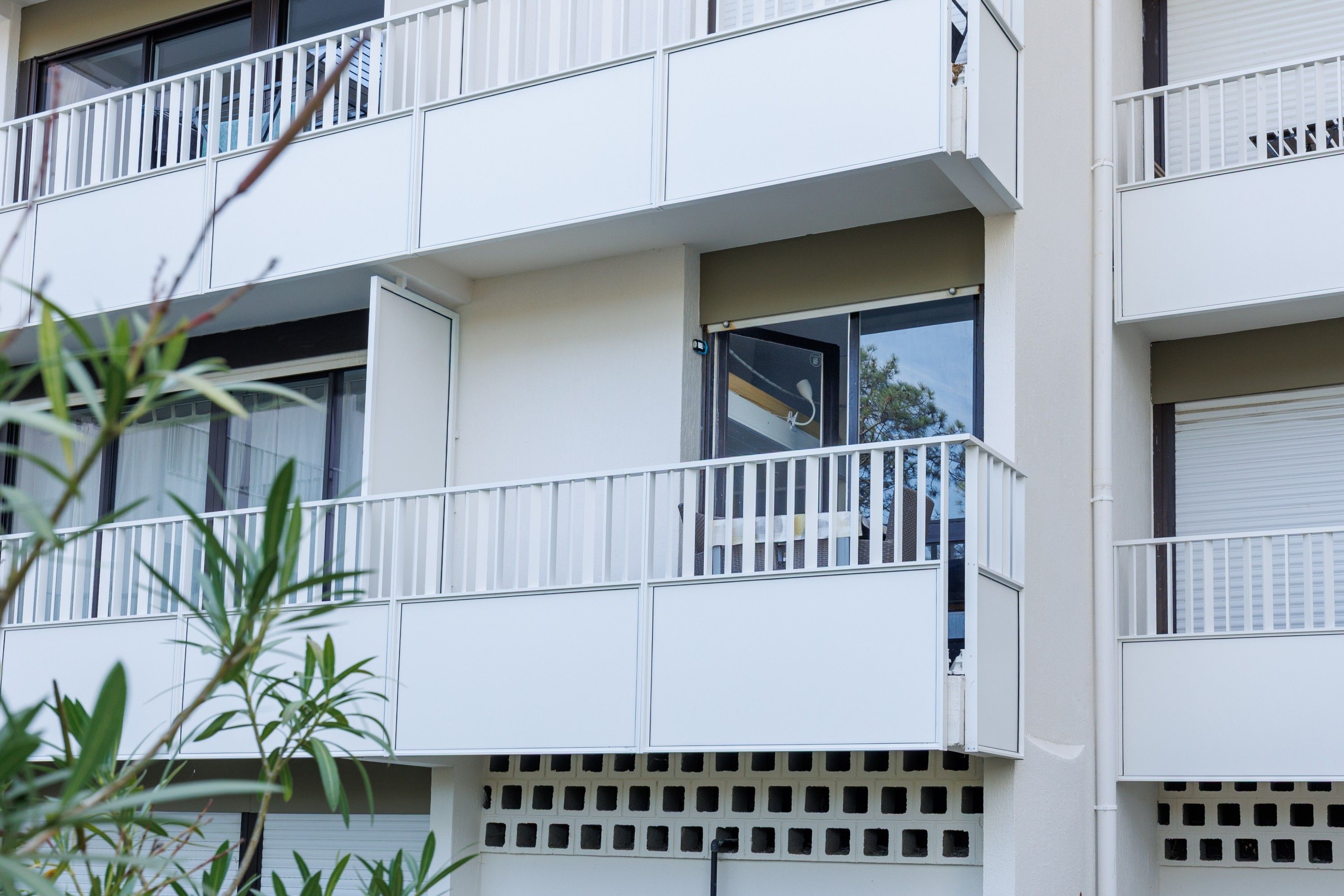 Un edificio de varios pisos con balcones, ventanas y un sistema de ventilación.