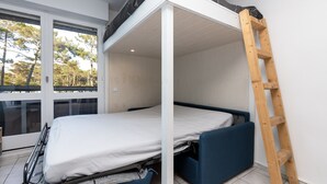 A bunk bed with a ladder, a window with a view of trees, and a door. - Studio Seignosse near the "Le Penon" beach (1 min) with balcony (Seignosse)