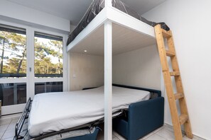 A bunk bed with a ladder, a window with a view of trees, and a door. - Studio Seignosse near the "Le Penon" beach (1 min) with balcony (Seignosse)