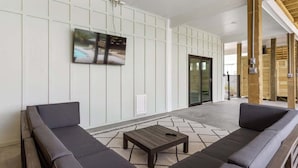 En moderne lobby med sofa, sofabord og et tv ophængt på væggen.