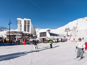 A ski resort with a large building labeled 'PalaFour' and a ski lift in operation.