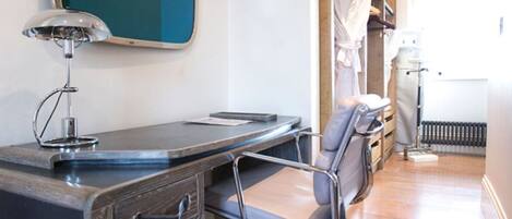 A modern office space with a desk, chair, and a large abstract art piece on the wall.