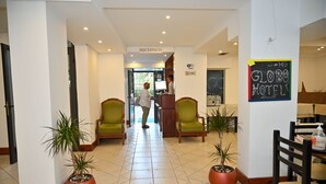 A reception area with a reception desk, a sign for the reception, and a chalkboard with "GLOBO HOTEL" written on it. - Hotel Globo (Durrës)