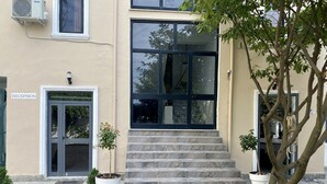 A building entrance with a reception desk, a welcome mat, and potted plants. - Hotel Globo (Durrës)