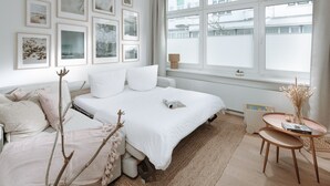 Un dormitorio con cama, mesita de noche y ventana con persianas.