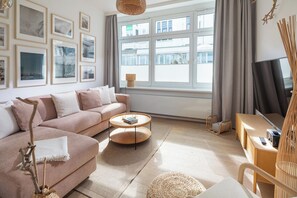 Una sala moderna con sofá, mesa de centro y mueble para televisor.