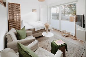 A modern living room with a sofa, a coffee table, and a TV. - // V I L L A F R E S E N A // Bude 3 (Norderney)