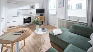 A modern, well-lit apartment with a kitchen, dining area, and living room. - // V I L L A F R E S E N A // Bude 6 (Norderney)