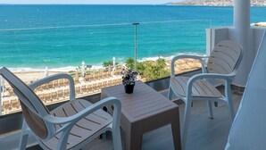 A balcony with a view of the sea, two chairs, a table, and a potted plant. - Hotel Emblem (Sarandë)