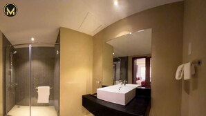 A modern bathroom with a glass-enclosed shower, a large white sink, and a mirror above it. - Muscat Express Hotel (Muscat)