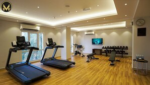 A modern gym with treadmills, a stationary bike, and weightlifting equipment. - Muscat Express Hotel (Muscat)