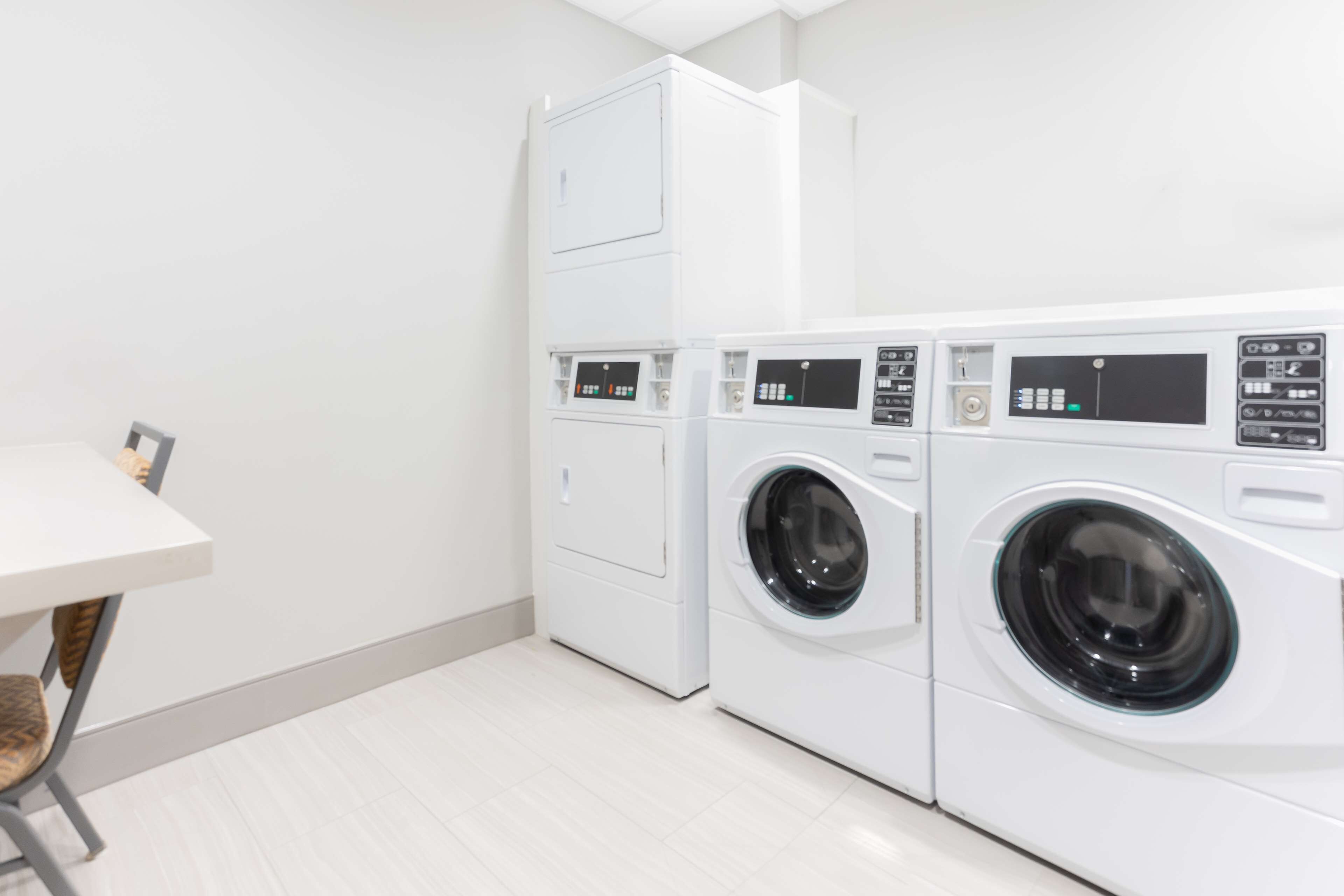 A laundry room with two washing machines and a table.