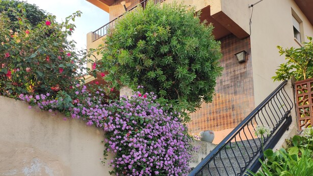 A staircase with a black metal railing leading to a building with a tiled roof and a balcony. - NIGRAN, Studio 10 minutes from Playa America (NIGRAN)