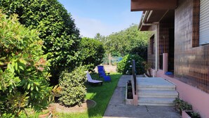 A residential garden with a pathway leading to a house. - NIGRAN, Studio 10 minutes from Playa America (NIGRAN)