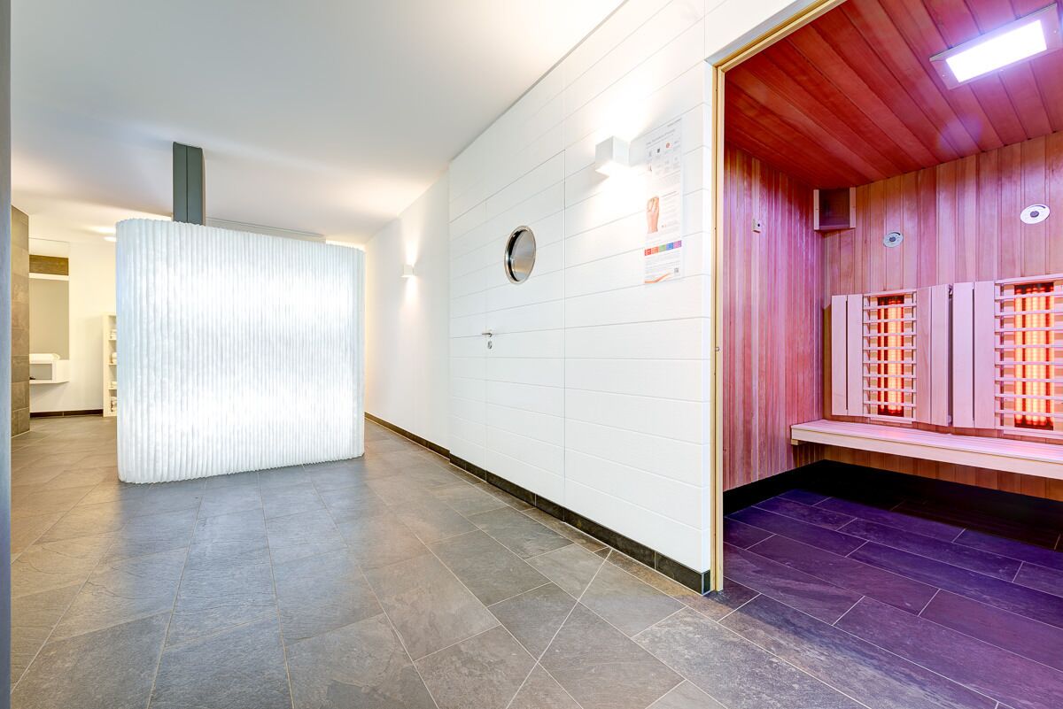 Un moderno vestíbulo de hotel con zona de recepción, sauna y suelo de baldosas.
