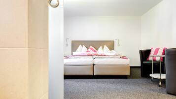 Una habitación de hotel con una cama, una silla y una mesita.