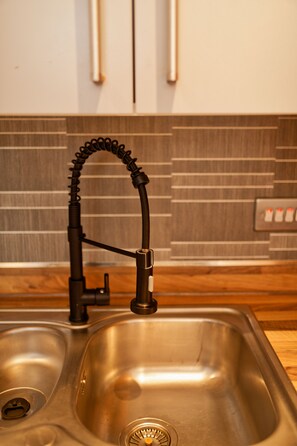 Uma pia de cozinha com uma torneira moderna e ralo aparente.