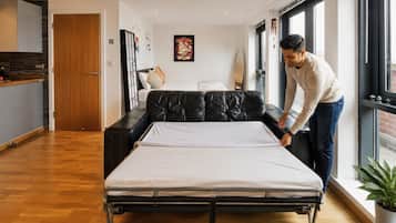 Una habitación con cama, sofá, ventana y puerta.