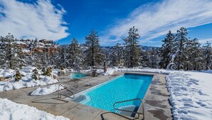 A rectangular pool with a clear blue water surface, surrounded by snow-covered ground and trees. - The Evergreen | AC, Pool, Hot Tub, Golf & Ski (Durango)