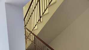 A staircase with a wooden handrail and metal balusters, leading to an upper floor.