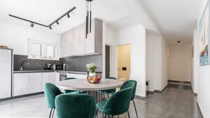 Una cocina moderna con comedor, que incluye una mesa redonda con sillas, un microondas y un lavamanos.