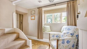 A room with a bench seat, a staircase, and a window with curtains. - Traditional Cotswold stone cottage sleeps 7 guests in 3 bedrooms - Little Mullions (Little Rissington, near Bourton-on-the-Water)