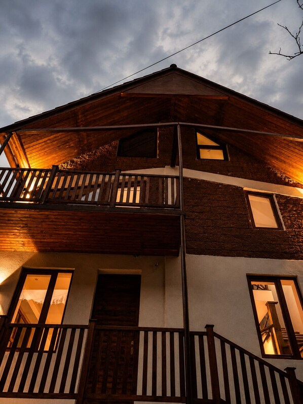 Ein zweistöckiges Gebäude mit Balkon, Tür und Fenstern.