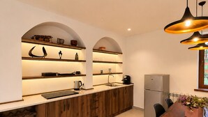 Une cuisine moderne avec des meubles en bois, un four encastré et un coin repas comprenant une table et des chaises.