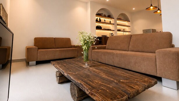 Un salon moderne avec un canapé, une table basse et une bibliothèque.