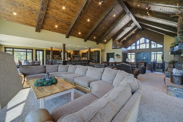 A spacious living area with a large sectional sofa, a wooden coffee table, and a fireplace. - Trail Ridge Lodge-7 Bedroom 4 miles from Deadwood (Deadwood)
