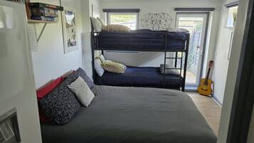A room with bunk beds, a guitar, and a window with a view.