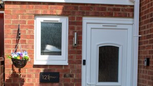 A small, enclosed outdoor area with a white door, a window, and a sign reading "121|STUDIO". - 121 Studio (Bishop's Stortford)