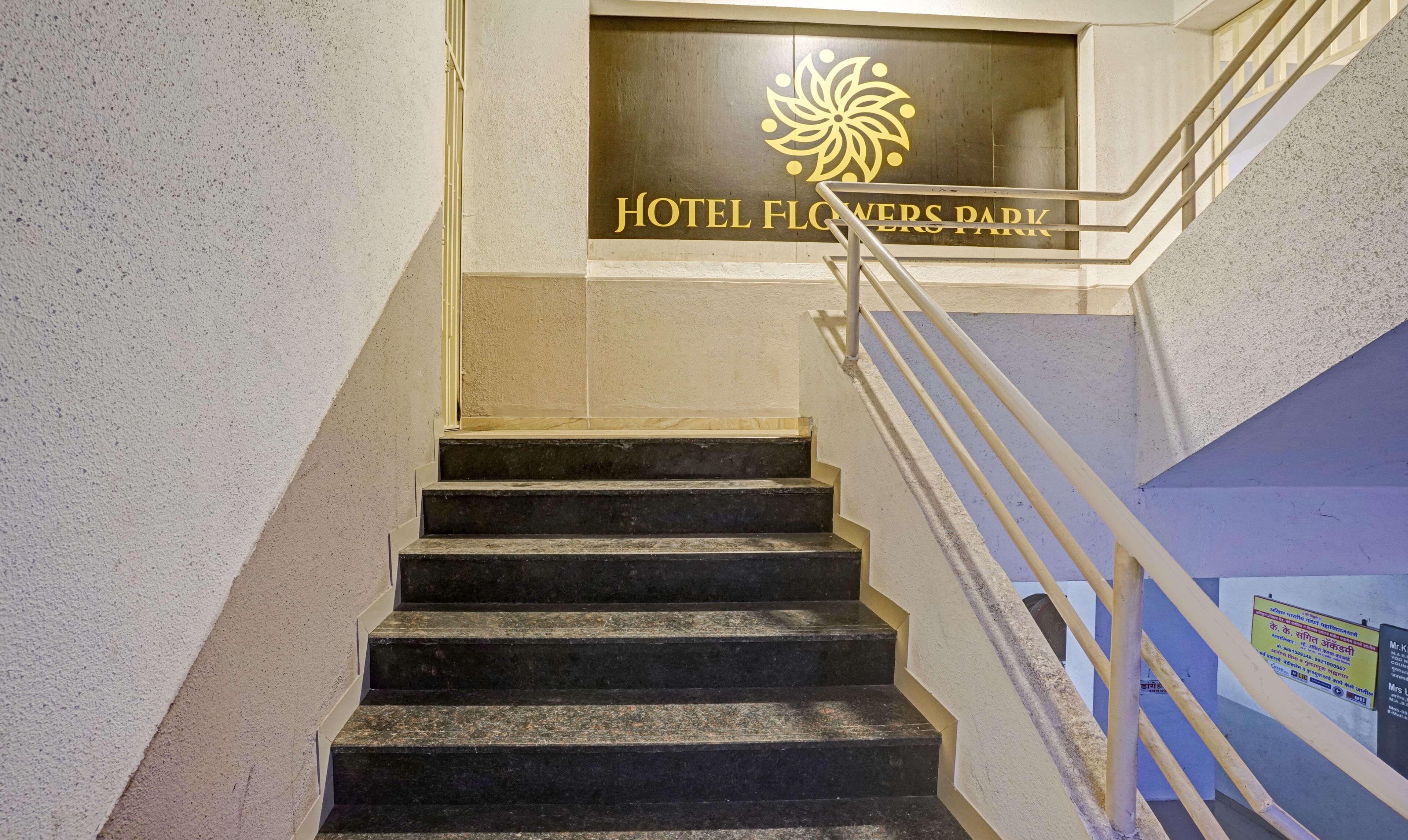 A staircase leading to a sign reading "Hotel Flowers Park".