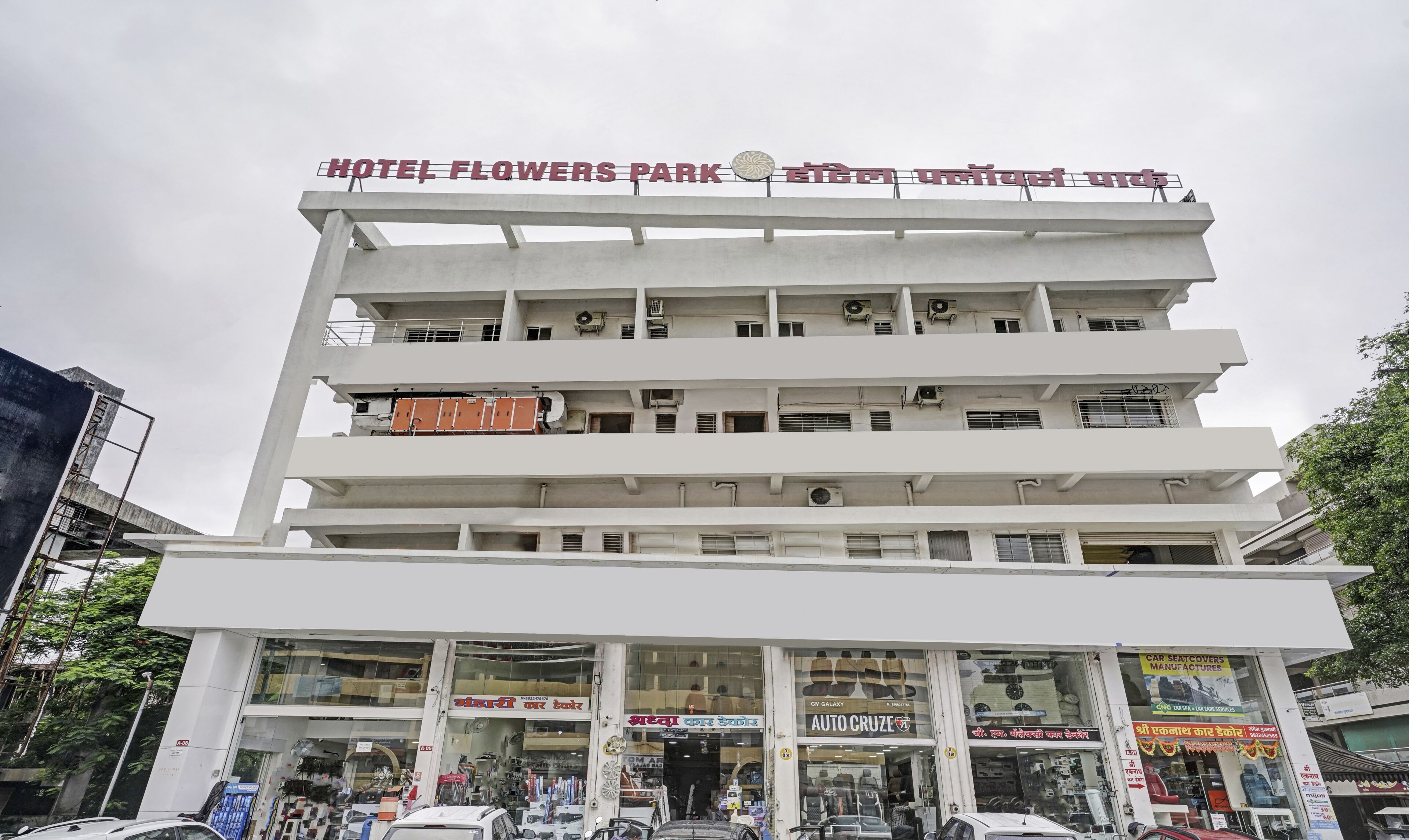 Un edificio de varios pisos con un letrero que dice "HOTEL FLOWERS PARK" en la parte superior.
