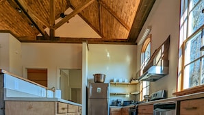 Una cocina amplia con pisos de madera, una isla central y un ventanal que proporciona luz natural.