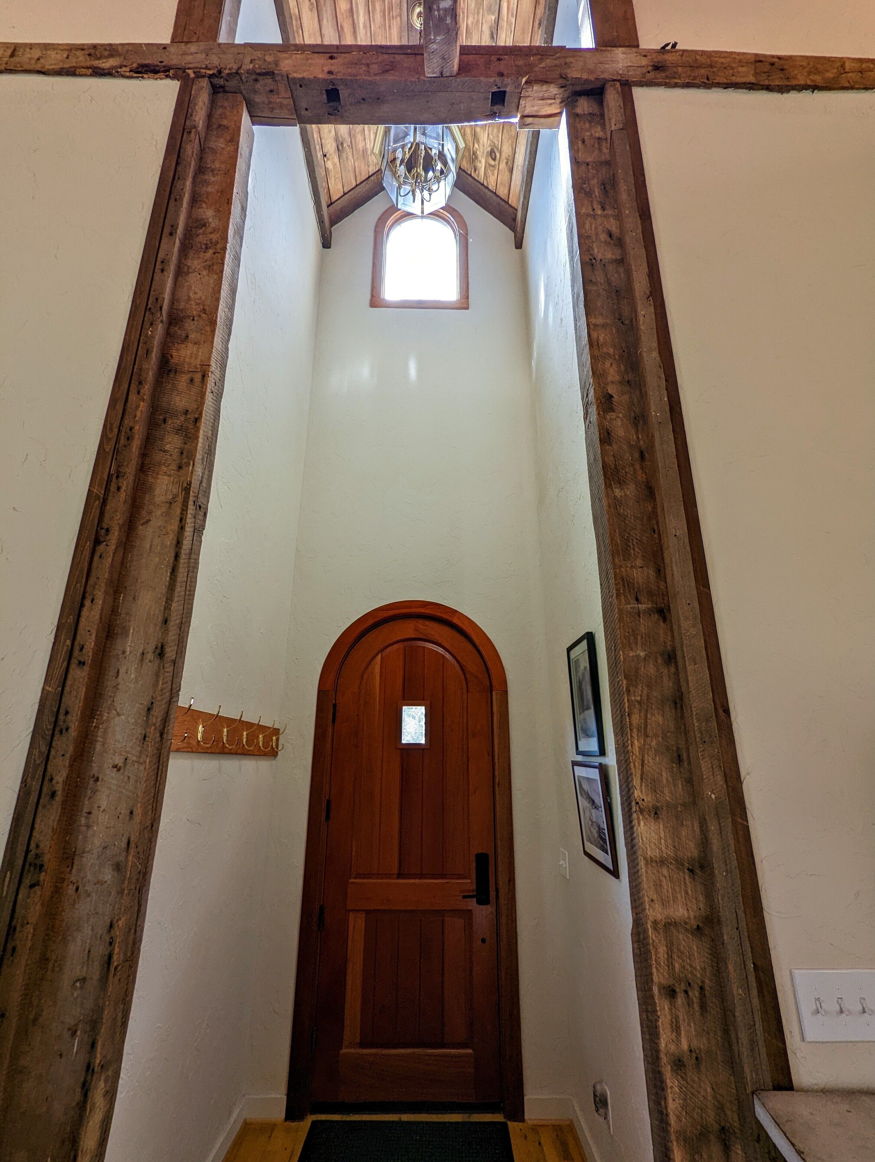 A wooden-framed staircase leading to a door with a small window above it.
