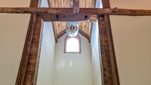Una escalera de madera que conduce a una puerta con un pequeño ventanal encima.