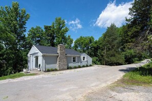 A single-story house with a stone chimney, a front porch, and a driveway leading to a road. - Warsaw Waterfront Home for 8, Near Belterra Casino (Sparta)