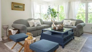 A living room with two checkered sofas, a blue coffee table, and a patterned rug.