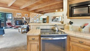 A modern kitchen with wooden cabinets, a built-in microwave, and a gas stove. - Snowflower 53: Spacious, Partial Mountain Views (Mammoth Lakes)
