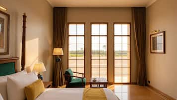 Habitación de hotel con una cama grande, un escritorio, una silla y vistas a través de las ventanas.