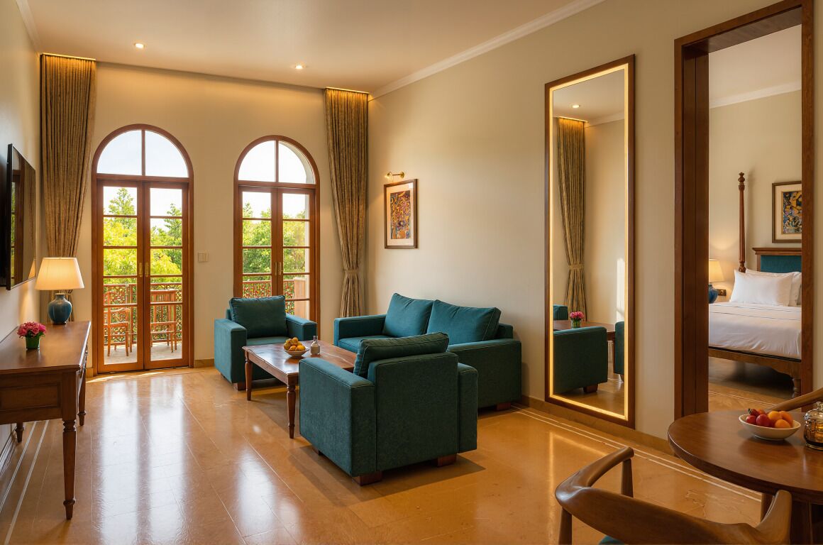 A hotel room with a sofa set, a dining table, a mirror, and a bed.