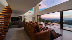 A modern interior with a staircase, a large sofa, and a panoramic view through large windows. - `Villa Majesta`Amazing View, luxury 4br Pool villa (Koh Samui)