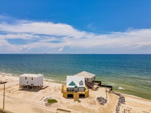 Ein Objekt direkt am Strand mit zwei Gebäuden, eines mit Balkon und das andere mit Veranda.