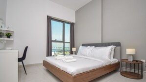 Una habitación de hotel moderna con una cama grande, un escritorio y una silla.